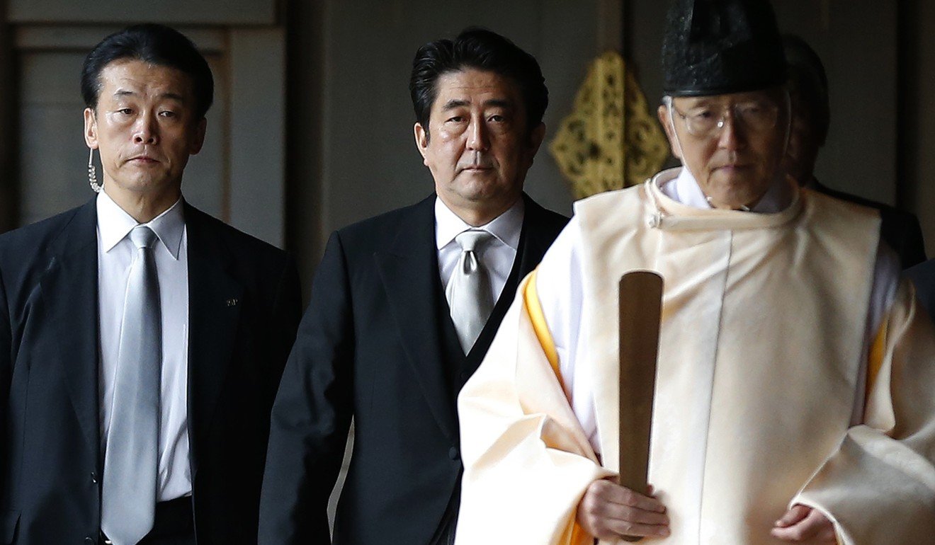 Japanese Prime Minister Shinzo Abe is led by a Shinto priest as he visits the Yasukuni Shrine, in Tokyo, in December 2013. Photo: Reuters