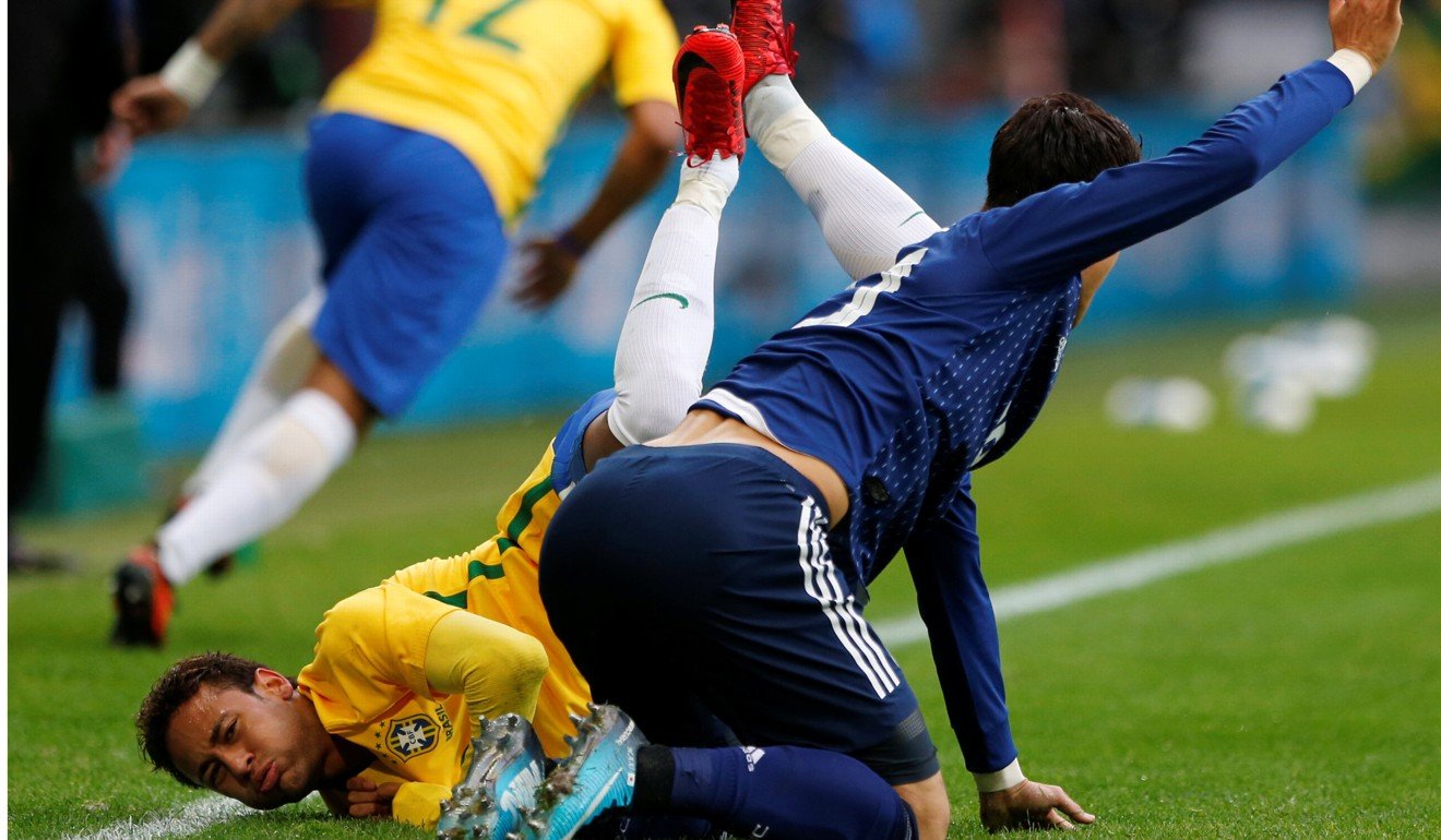 Neymar hits the turf in a challenge by Hiroki Sakai. Photo: Reuters