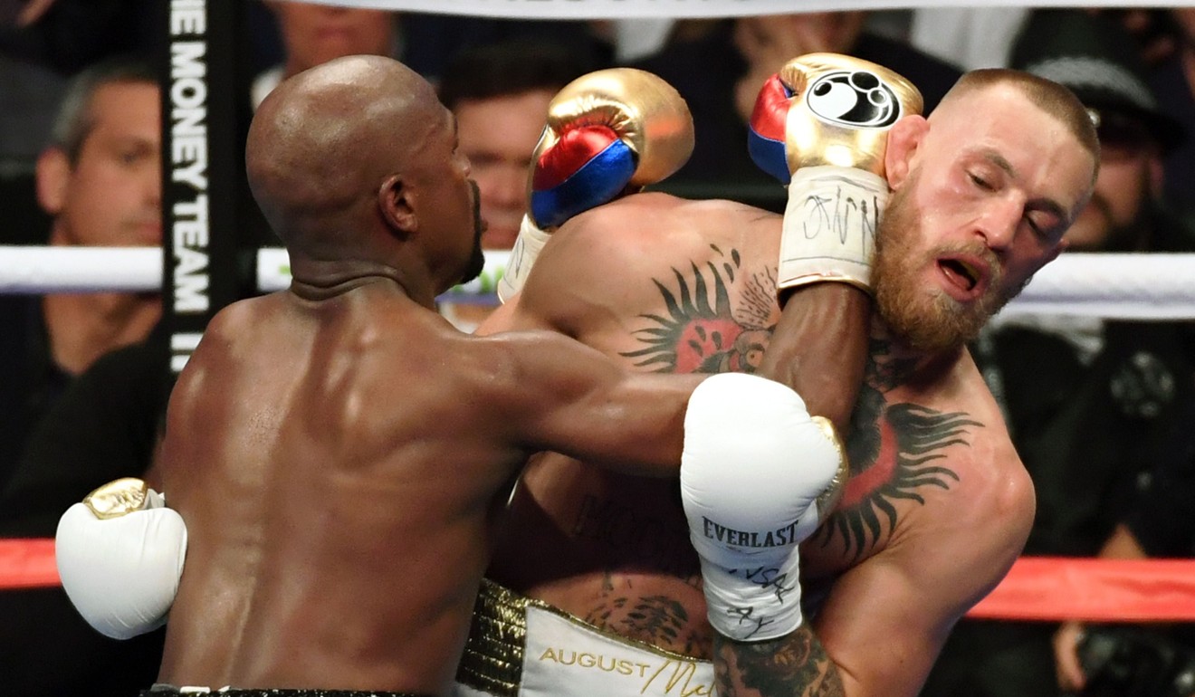 Floyd Mayweather Jnr throws a punch at Conor McGregor. Photo: AFP
