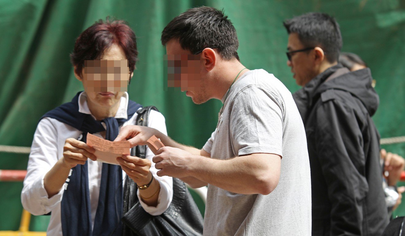 A man is seen trying to sell a ticket to a woman in Causeway Bay. Photo: Edward Wong