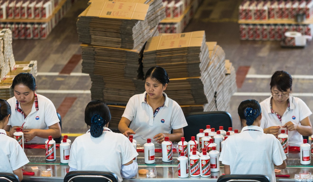 Workers pack bottles of baijiu at a Kweichow Moutai factory in Guizhou province. The company’s shares jumped 4.5 per cent to a record high of 719.11 yuan on Thursday. Photo: Photo: EPA