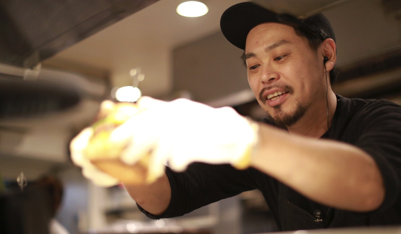 Yutaka Yanagisawa, owner of Munch's Burger Shack restaurant, prepares a burger. Photo: AP
