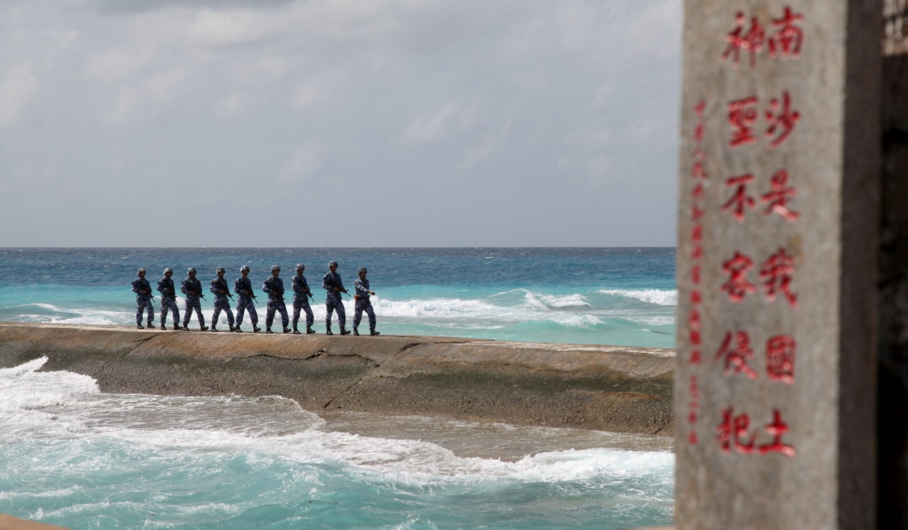 Soldiers from China's People's Liberation Army Navy patrol near a sign in the Spratly Islands, known in China as the Nansha Islands, which are also claimed by the Philippines. International observers have feared that China may use its growing power to enforce its territorial claims in the South China Sea through its military. Photo: Reuters