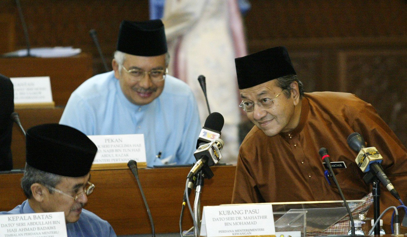 Mahathir Mohamad (right) takes his seat next while defence minister Najib Razak (centre) looks on in 2003. Photo: Reuters