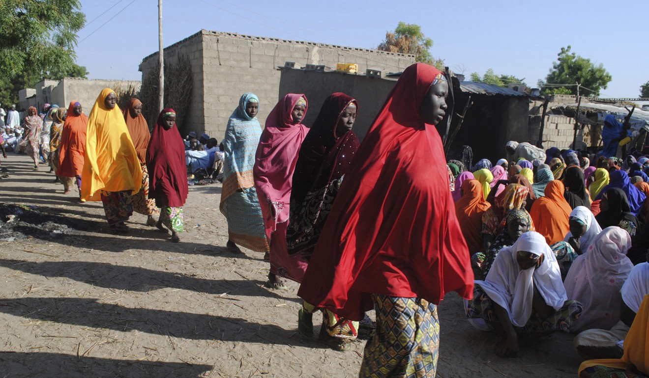 Women walk past others mourning the death of a family member after a suicide attack in Maiduguri, Nigeria, which was blamed on Boko Haram. The home of the group’s founder will be turned into a museum. Photo: AP