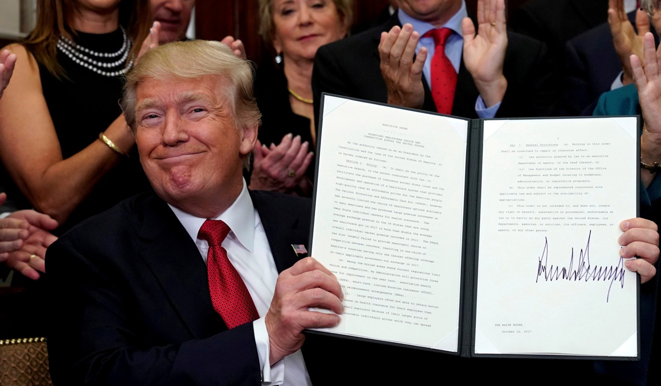 US President Donald Trump smiles after signing an Executive Order to make it easier for Americans to buy bare-bone health insurance plans and circumvent Obamacare rules. He commended Senate Majority Leader Mitch McConnell after Republicans successfully passed laws to repeal parts of the Affordable Care Act. Photo: Reuters