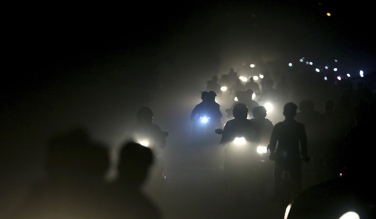 Indian motorists ride through a thick blanket of smog and dust on the outskirts of New Delhi. Photo: AP