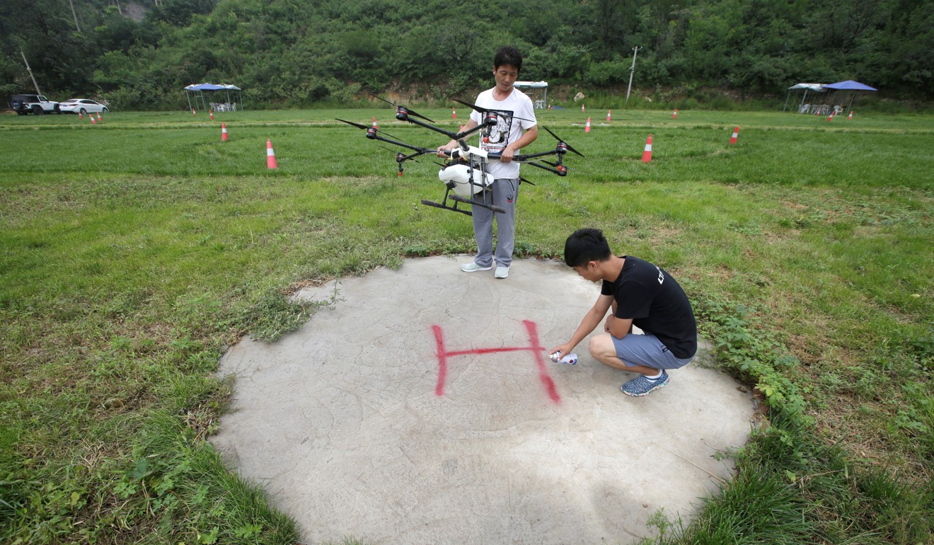 An instructor setting up a landing sign as a trainee prepares to learn to fly a drone outside Beijing. Photo: Jason Lee