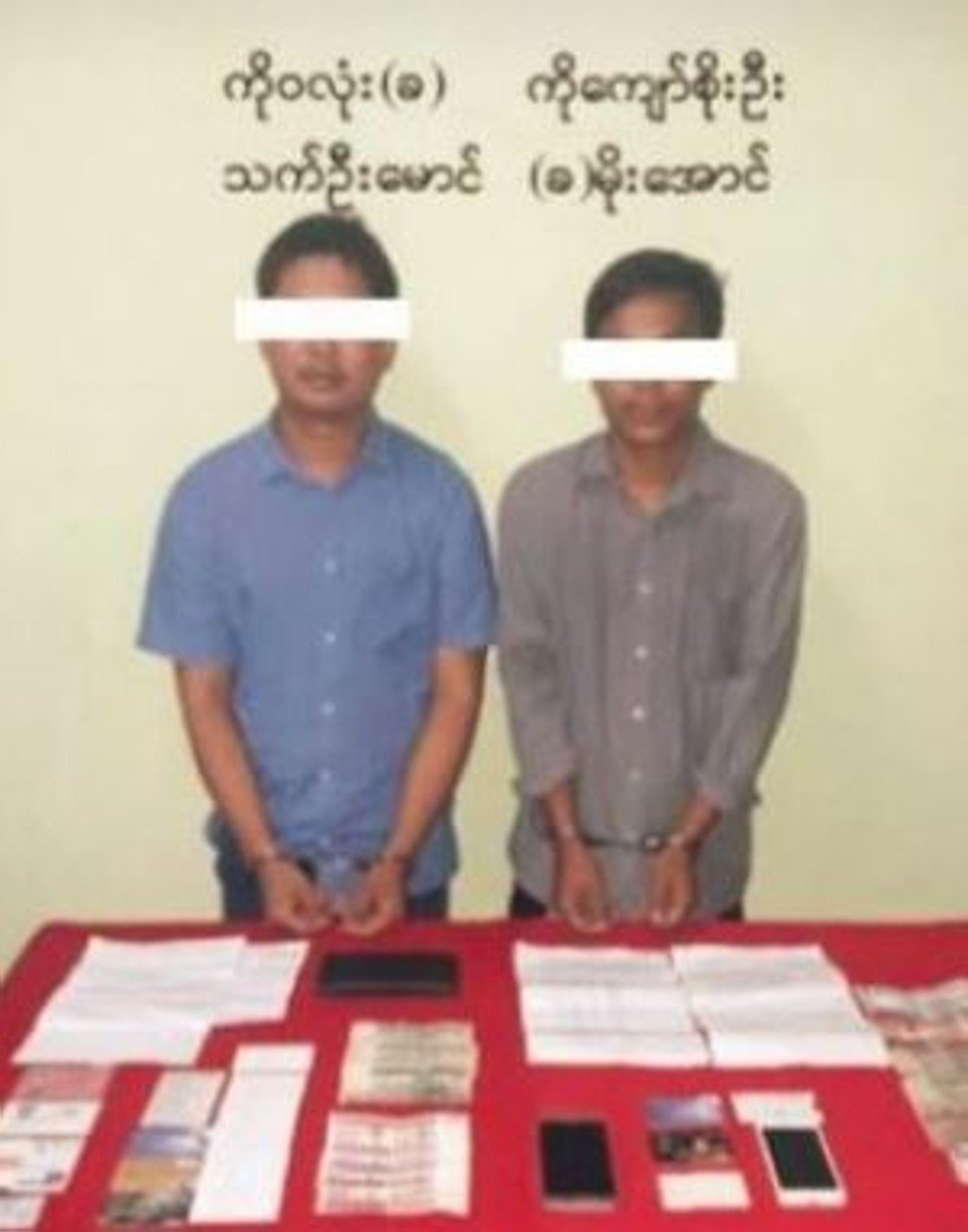 Myanmar's Information Ministry posted a photo of the two journalists in handcuffs, standing behind a table bearing documents, cellphones and currency. Photo: Myanmar Information Ministry