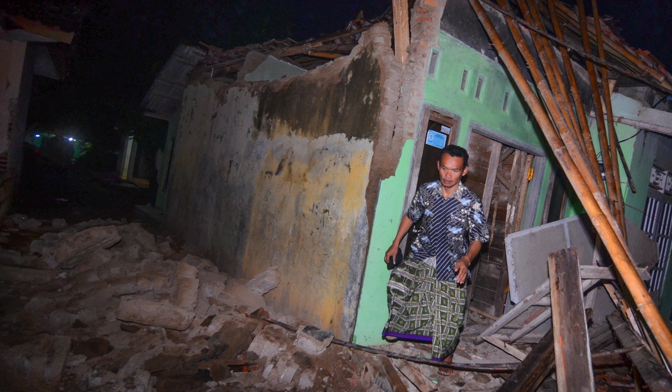 A man walks out of a damaged house in Tasikmalaya, West Java. Photo: EPA