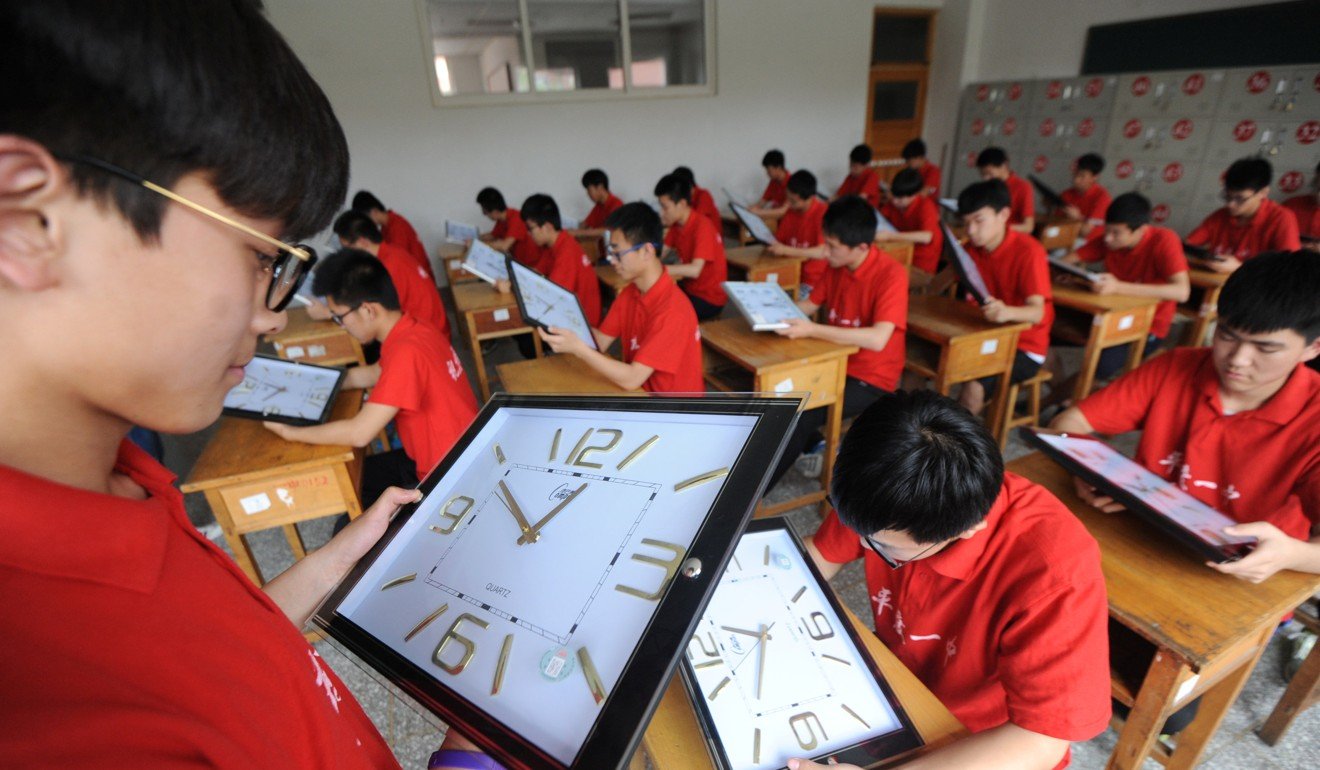 Staff members calibrate clocks ahead of China's annual National College Entrance Exam, also known as Gaokao, at a high school in Qingdao, Shandong province, on June 5, 2017. Photo: Reuters