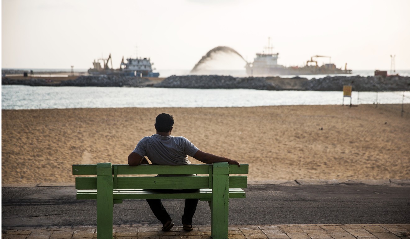 A man looks out towards a dredging vessel operating at the construction site of the Colombo Port City development, a Chinese-financed US$1.4 billion project under Beijing’s belt and road plan. Photo: Bloomberg