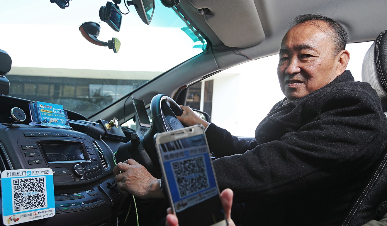 A taxi driver in Lai King uses Alipay to settle fares. Innovations such as Alipay and WeChat Pay have forced companies accustomed to using cash to change course. Photo: Edward Wong
