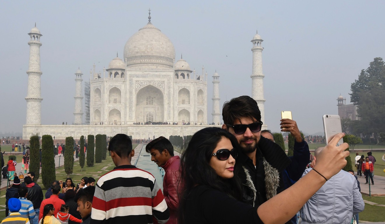 Visitors take a selfie photograph in front of the Taj Mahal in Agra. Photo: AFP