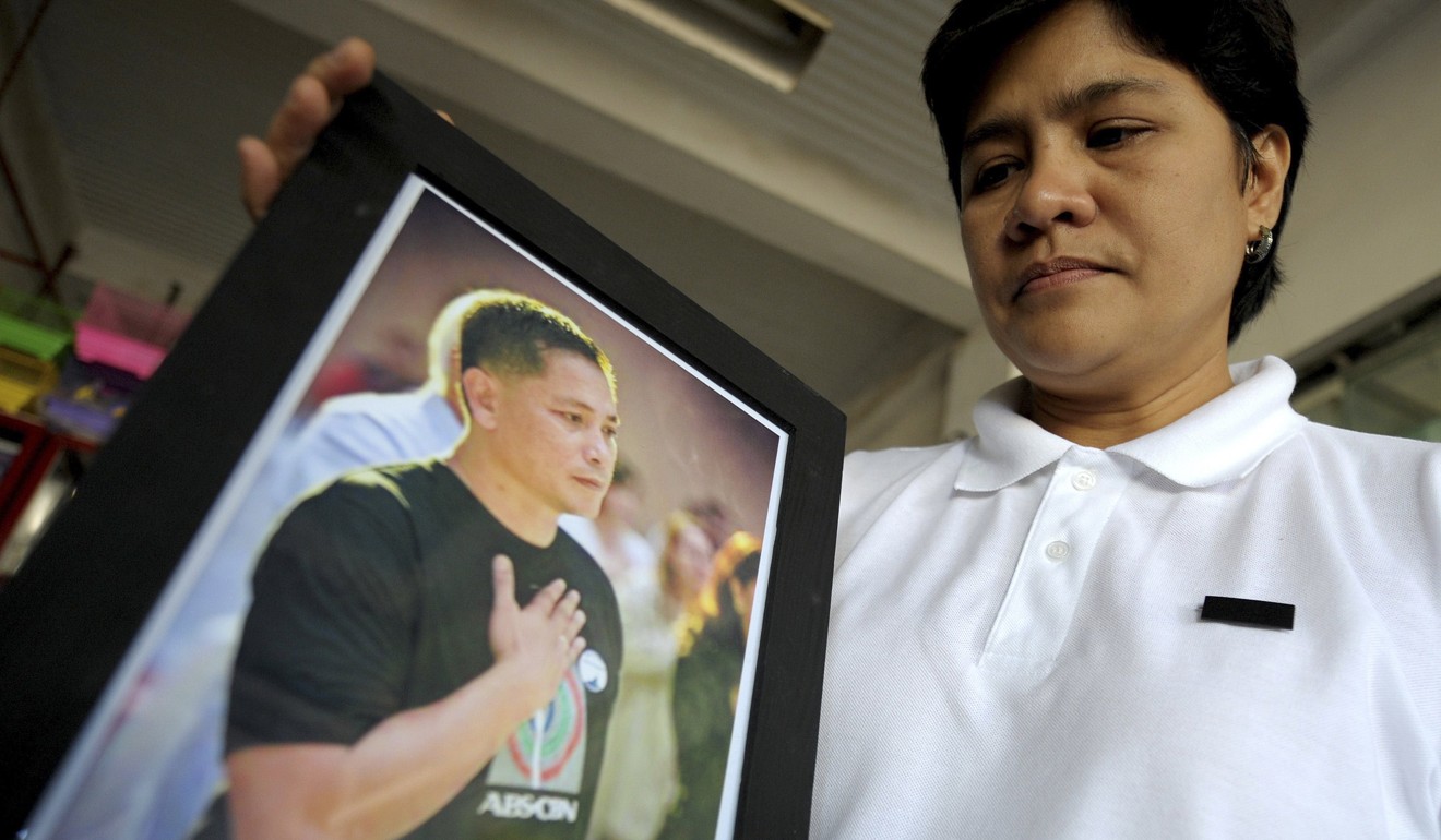 File photo of Patricia Ortega, wife of slain Philippine conservationist Gerry Ortega, with a picture of her husband. Photo: AFP