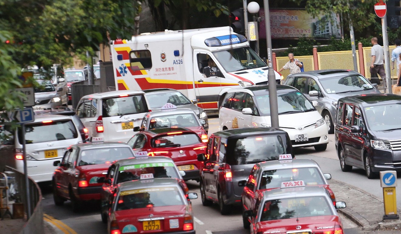 An ambulance gets stuck in a traffic jam in Wan Chai. The Hong Kong government has noted the unchecked growth of private cars in recent years but has yet to form an effective policy to deal with it. Photo: Felix Wong