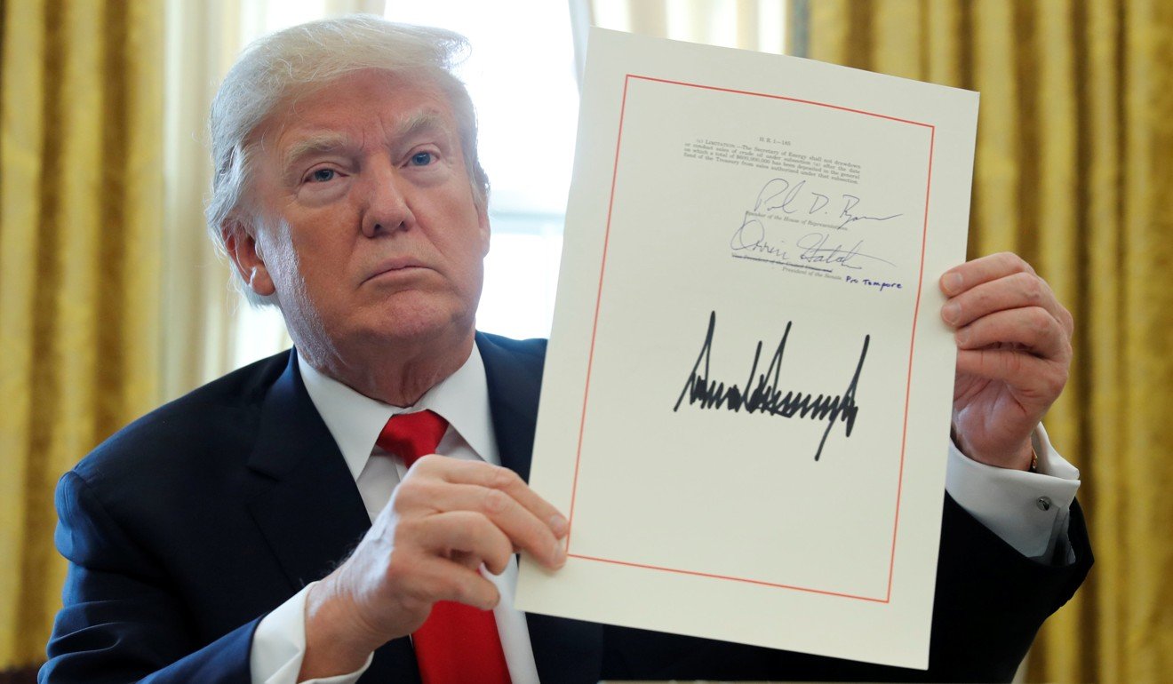 US president Donald Trump displays his signature after signing the $1.5 trillion tax overhaul plan in the Oval Office of the White House in Washington on December 22. Photo: Reuters
