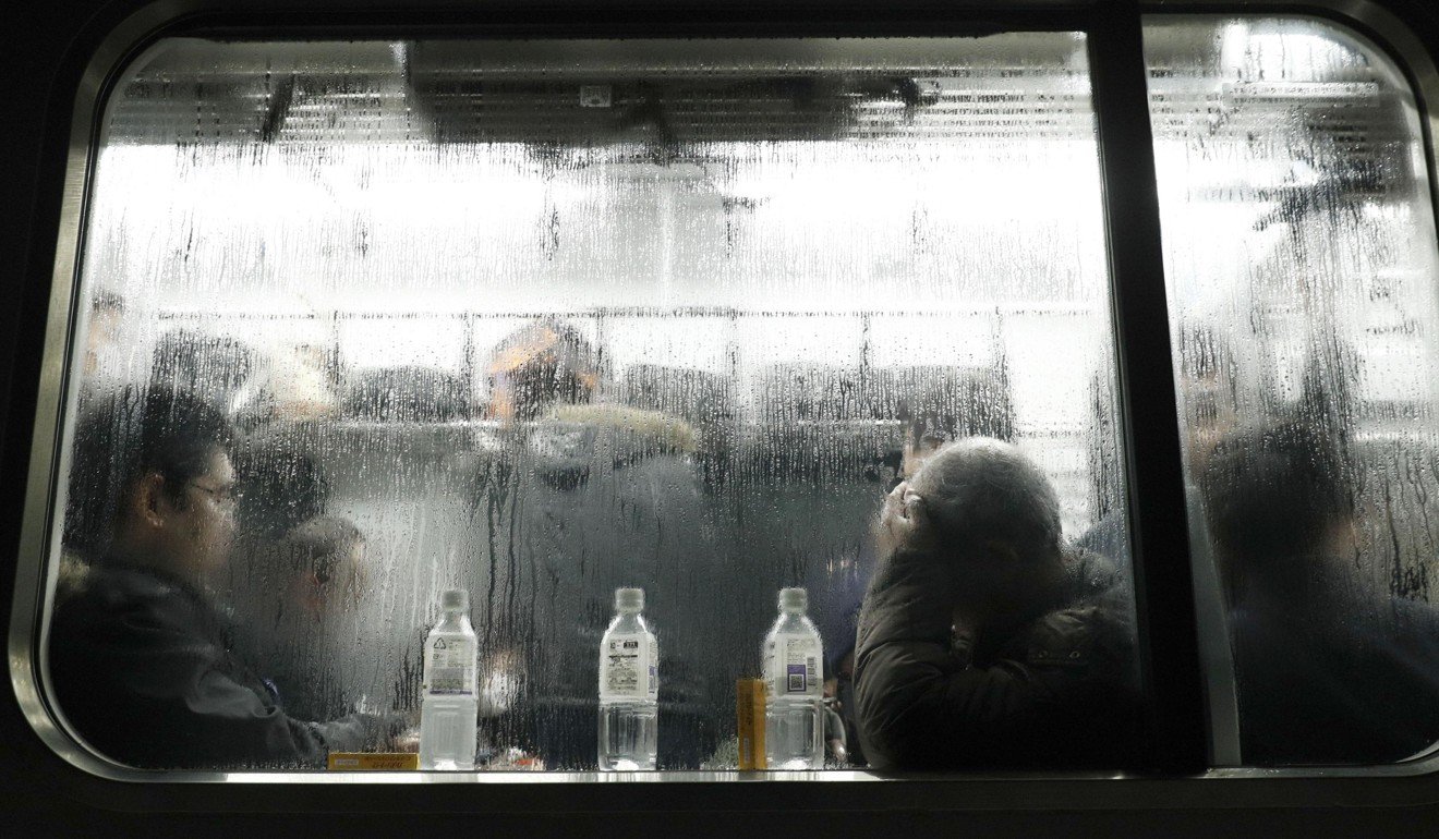 Passengers wait for the train service to resume after it became trapped by thick snow. Photo: Kyodo