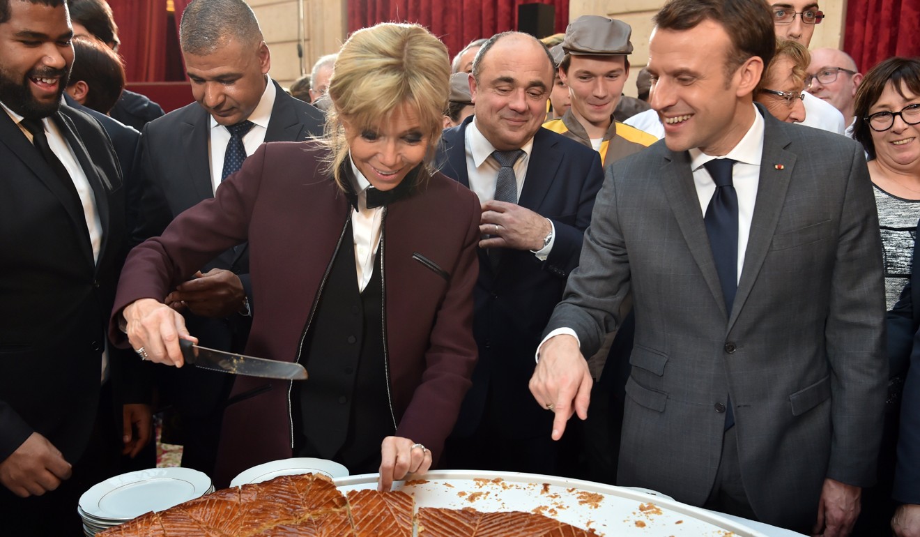 French President Emmanuel Macron and his wife Brigitte cut slices of a traditional epiphany cake during a ceremony at Elysee palace in Paris on January 12, 2018. Photo: EPA