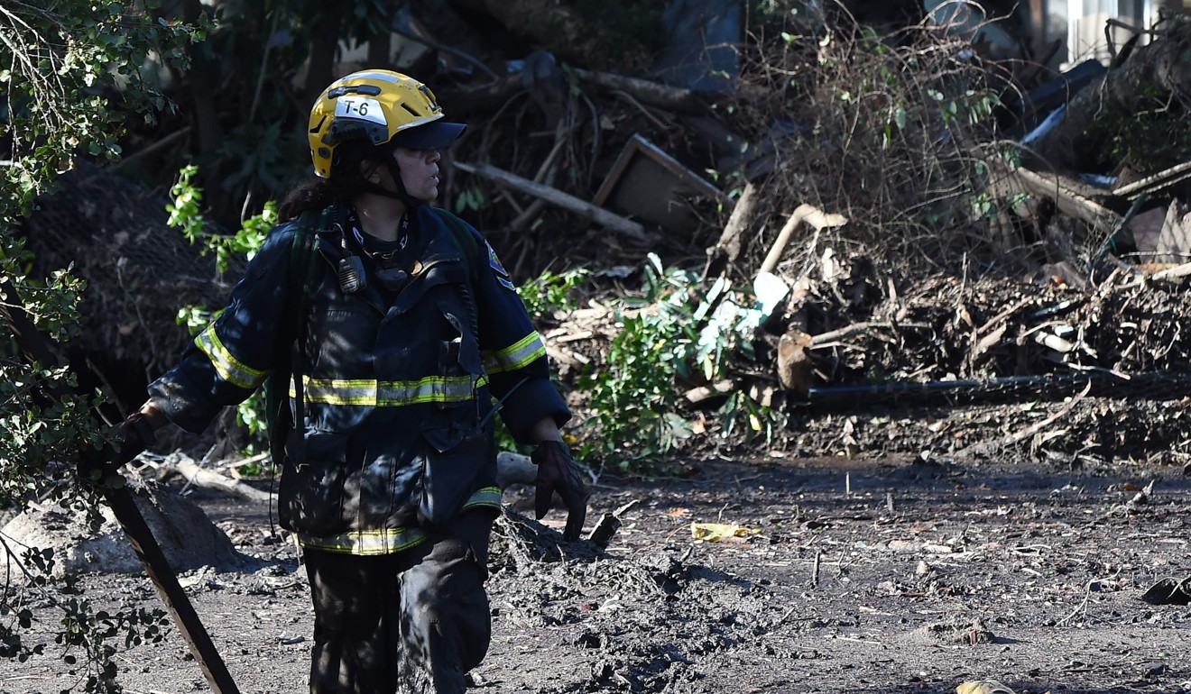 File photo taken on January 10, 2018 shows a member of the Orange County Fire Department Urban Search and Rescue team looking for survivors amid the mud, debris and destruction caused by a massive mudflow in Montecito, California. Photo: AFP