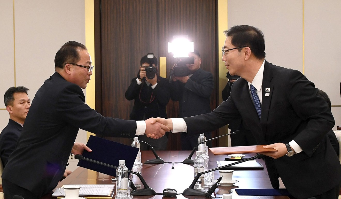 South Korean chief delegate Chun Hae-Sung (R) shaking hands with North Korean chief delegate Jon Jong-Su (L) as they exchange joint statements agreeing to march together under a single flag at the Winter Olympics. Photo: AFP