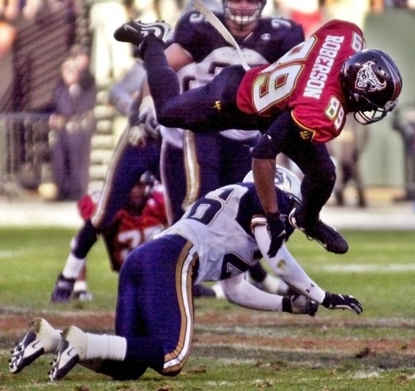 San Francisco Demons wide receiver Brian Roberson jumps over Los Angeles Xtreme cornerback Dell McGee during an XFL game in its first season. Photo: AP