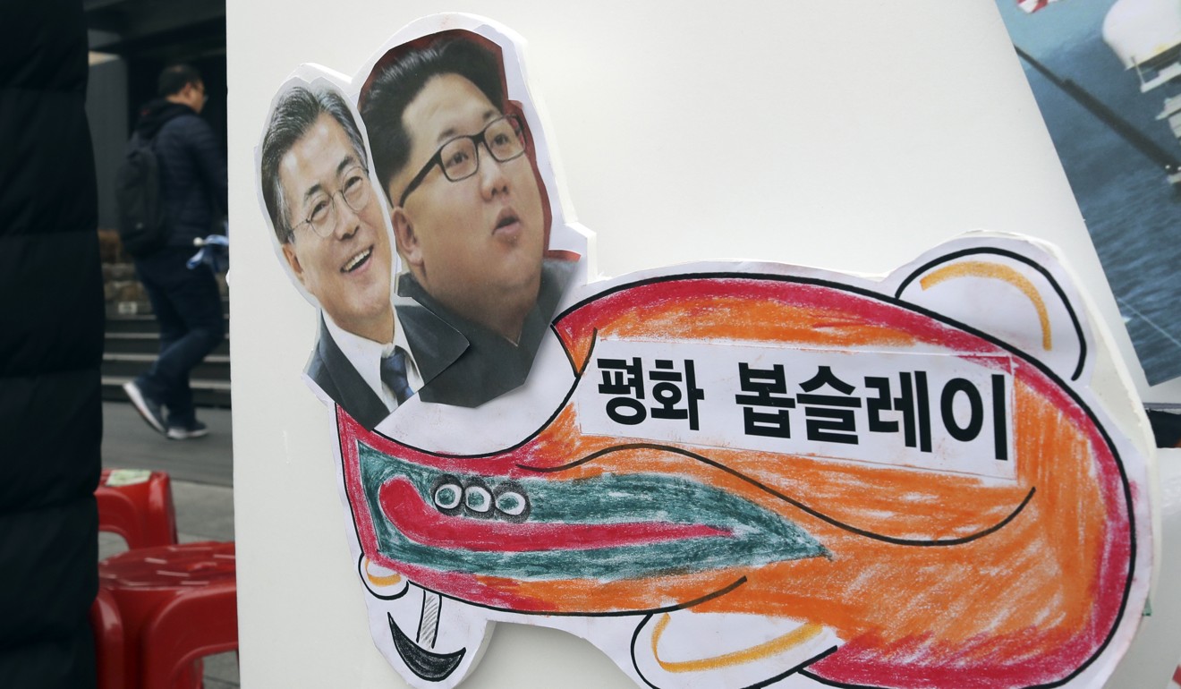 Pictures of South Korean President Moon Jae-in (left) and North Korean leader Kim Jong-un are seen on a sign during a rally for a peaceful Winter Olympics. The countries reached an agreement on North Korea’s Olympics participation in early January. Photo: AP