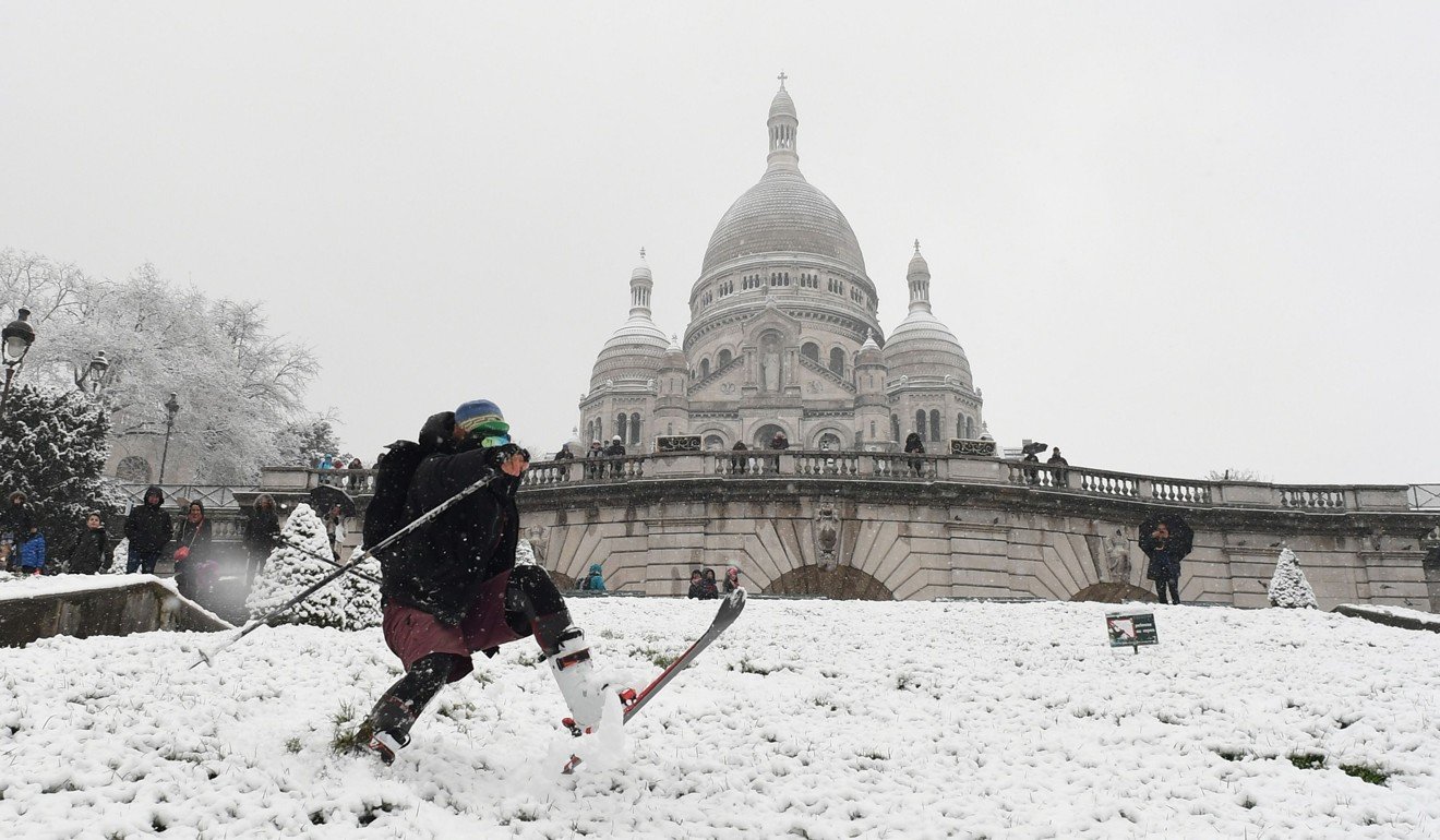 A man skis down the snow-covered Montmartre hill in front of the Basilica of the Sacred Heart Paris. Photo: Agence France-Presse