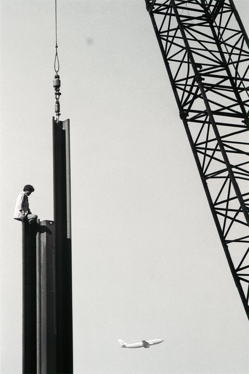 A worker, without any safety harness, sitting on the tip of a 20-metre-high steel piling in Quarry Bay in 1989. Photo: SCMP