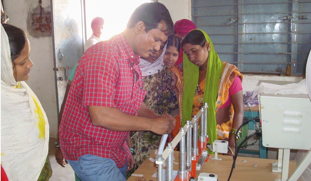 Muruganantham shows the sanitary pads to women villagers.
