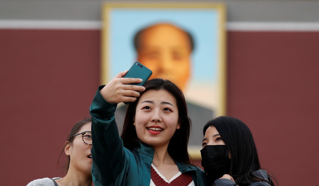 Women take pictures of themselves in front of a portrait of the late Chinese chairman Mao Zedong at the Tiananmen gate in Beijing. Photo: Reuters
