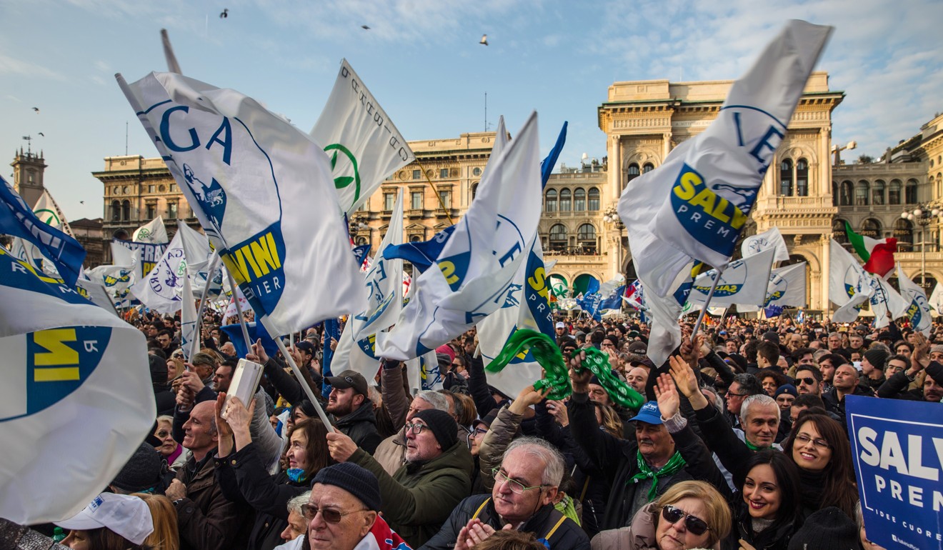 Attendees wave flags and gather during an election campaign rally for The League party at Duomo Square in Milan. Photo: Bloomberg