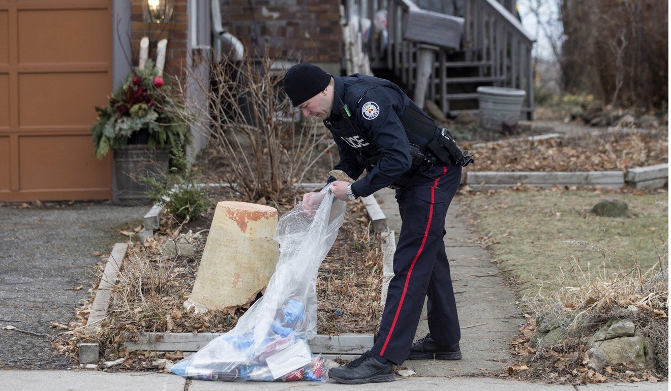 In this January 29, 2018 file photo, a police officer investigates outside a home on Mallory Crescent in Toronto, where Bruce McArthur did landscape work. Photo: AP