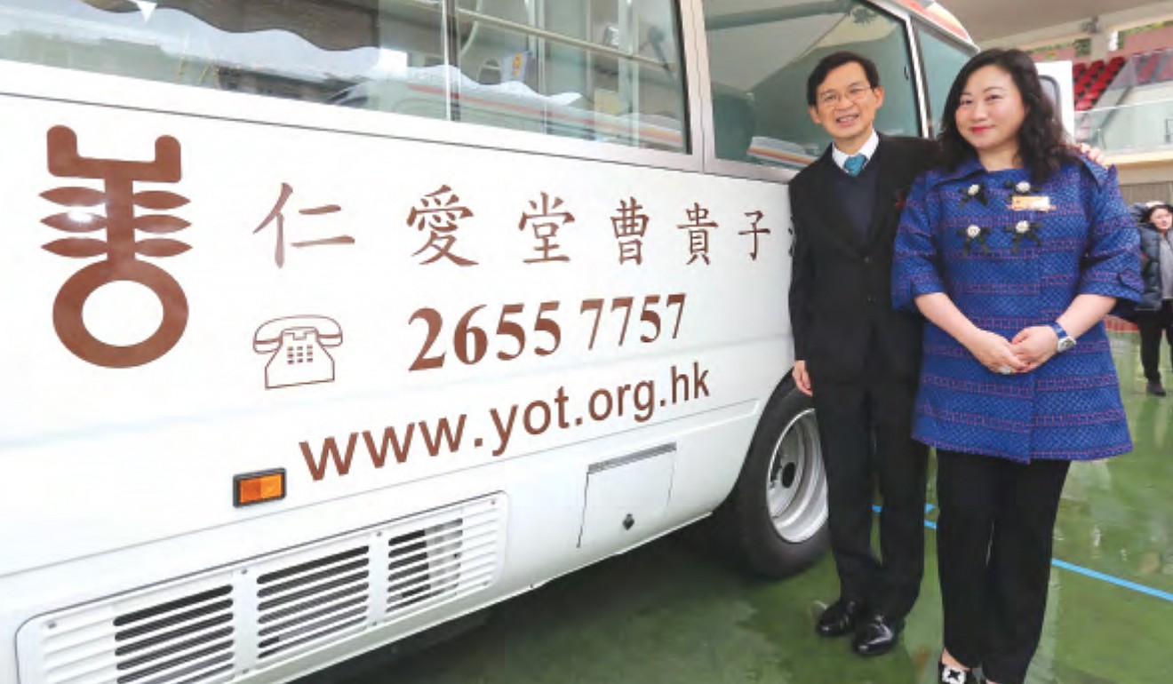 Cho Kwai Chee (left) stands next to the Yan Oi Tong Chinese Traditional Medicine mobile van that was named after him. Photo: Handout