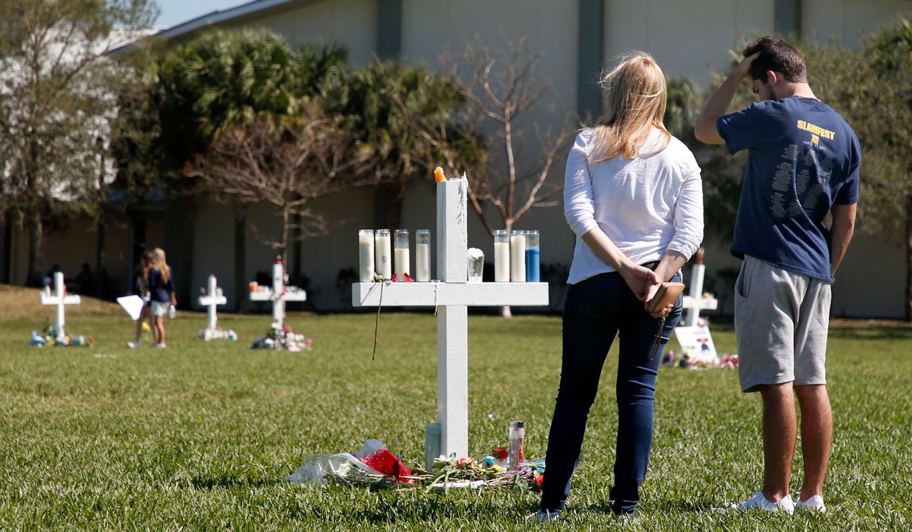 Mourners look at a memorial for victims of the Marjory Stoneman Douglas High School shooting in Florida. Photo: AFP
