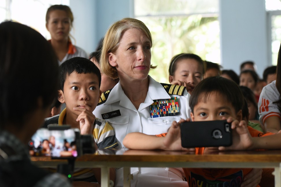 A US Navy official sits with children during a visit to the “Da Nang Centre supporting for Agent Orange victims” in Da Nang, Vietnam on Wednesday. Photo: EPA-EFE