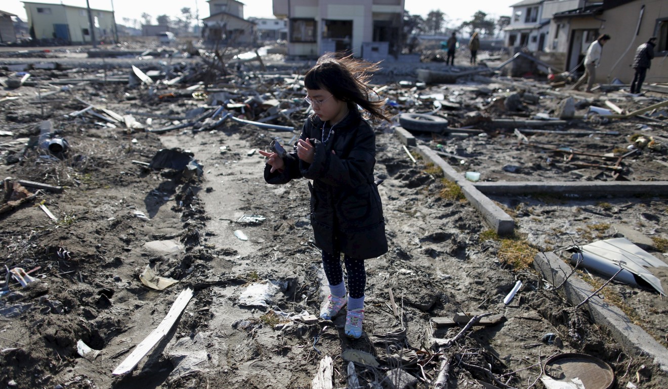 Wakana Kumagai, 7, visits the spot in Miyagi prefecture where her house once stood, before it was washed away by the March 11, 2011 tsunami. Photo: Reuters
