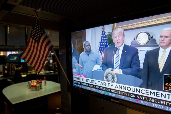 US President Donald Trump speaks on television as traders work on the floor at the closing bell of the New York Stock Exchange. Photo: AFP