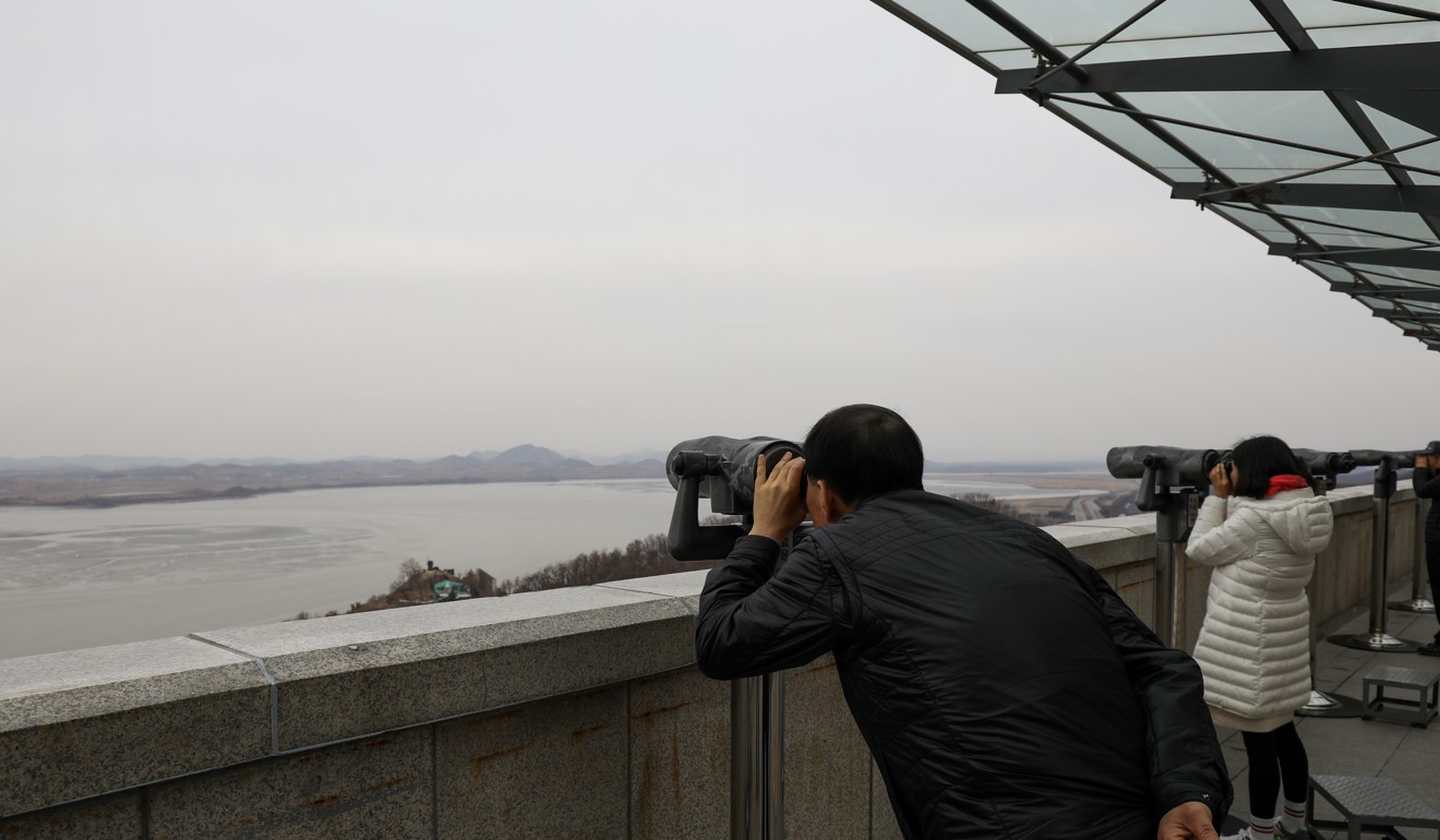 Visitors use binoculars to view the North Korean village of Gaepung-Gun from the Odusan Unification Observatory near the demilitarised zone in Paju, South Korea. Photo: Bloomberg