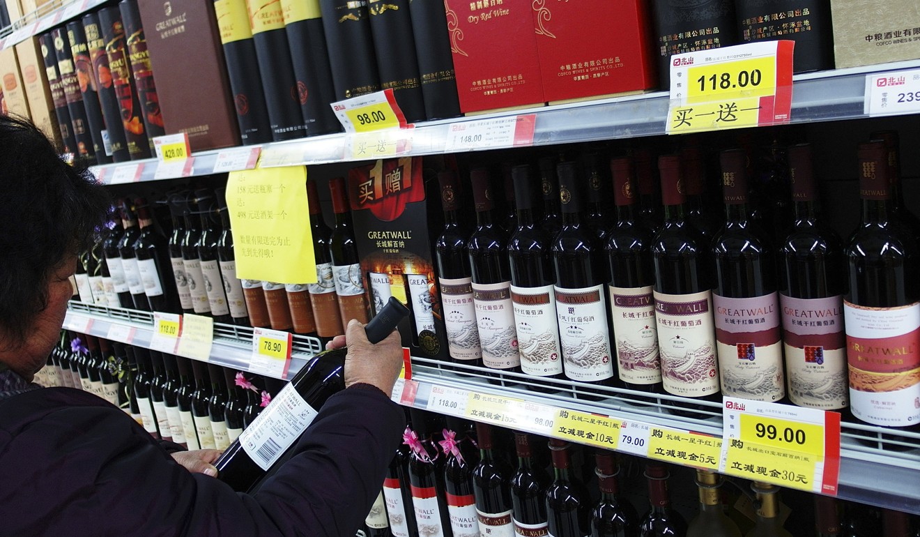 A shopper chooses wine in a supermarket in Yichang, Hubei province, in February 2014. Photo: AFP