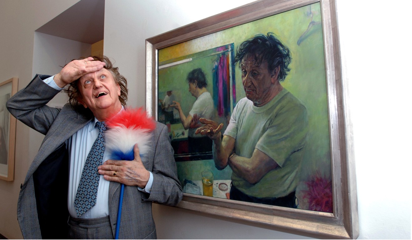 Dodd poses with a tickling stick by an oil on canvas portrait of him by artist David Cobley. Photo: AP