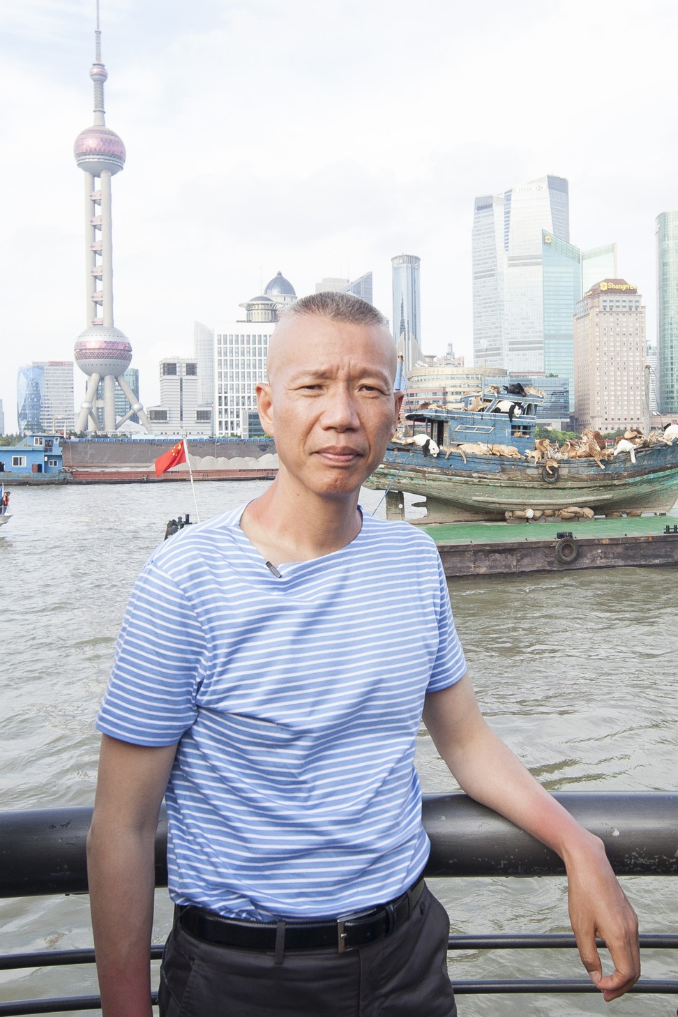 Cai Guoqiang standing in front of The Ninth Wave sailing on the Huangpu River. Photo: Cai Studio