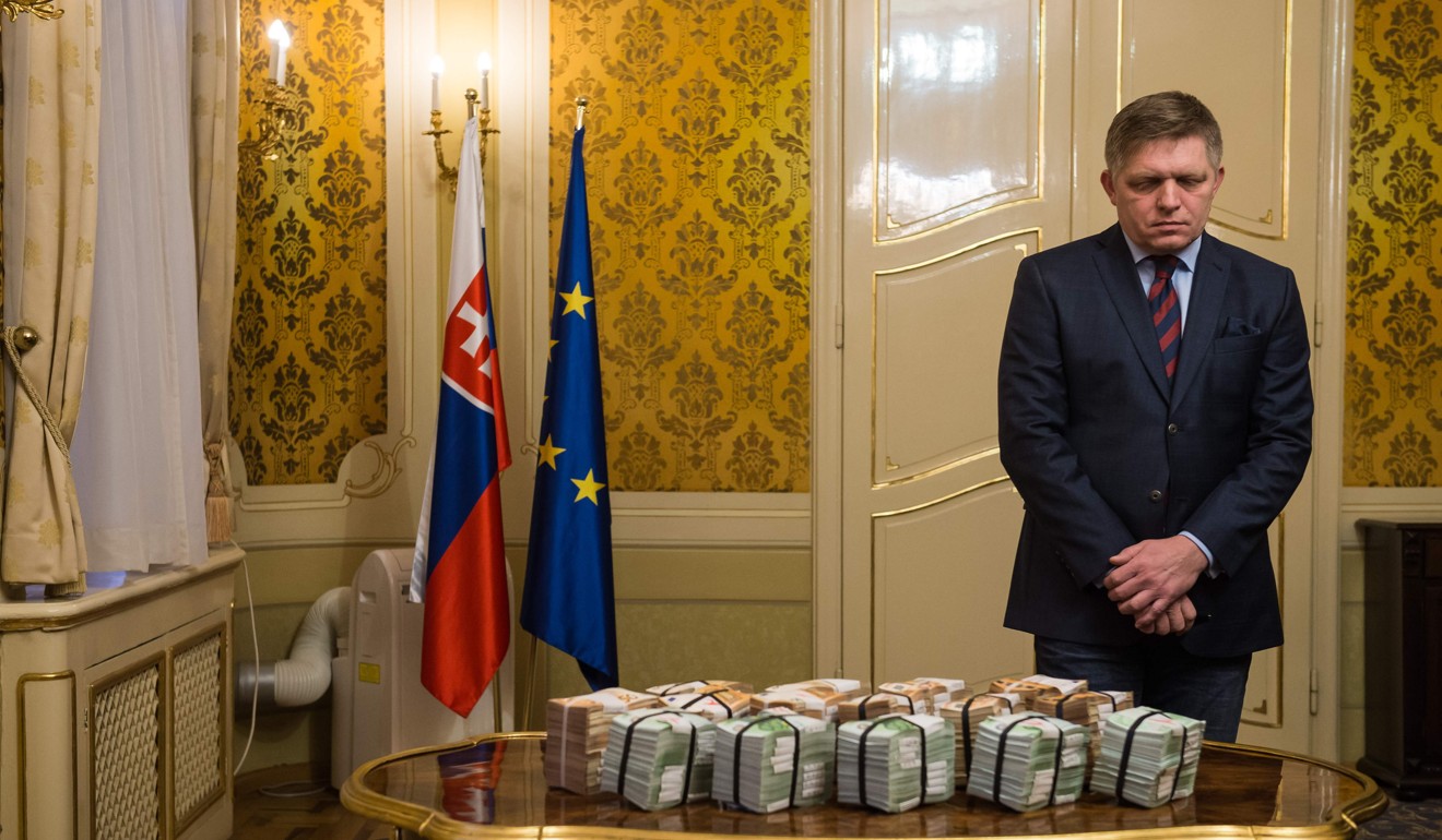 Slovak Prime Minister Robert Fico stands behind bundles of banknotes during a press conference during which he offered his resignation, after the murder of a leading journalist who investigated high-profile tax fraud and political corruption. Photo: AFP