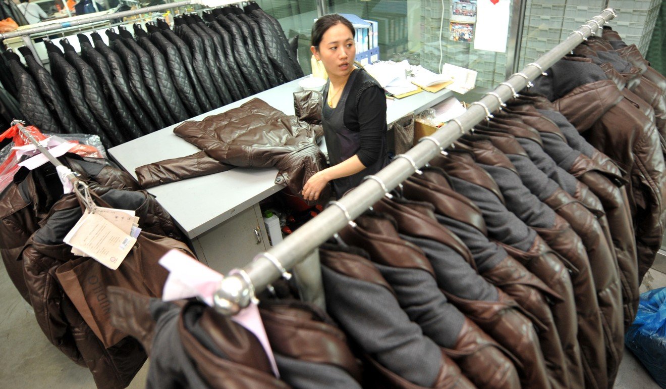 An employee of a leather clothing manufacturer in Haining attaches labels to leather jackets. Photo: Xinhua