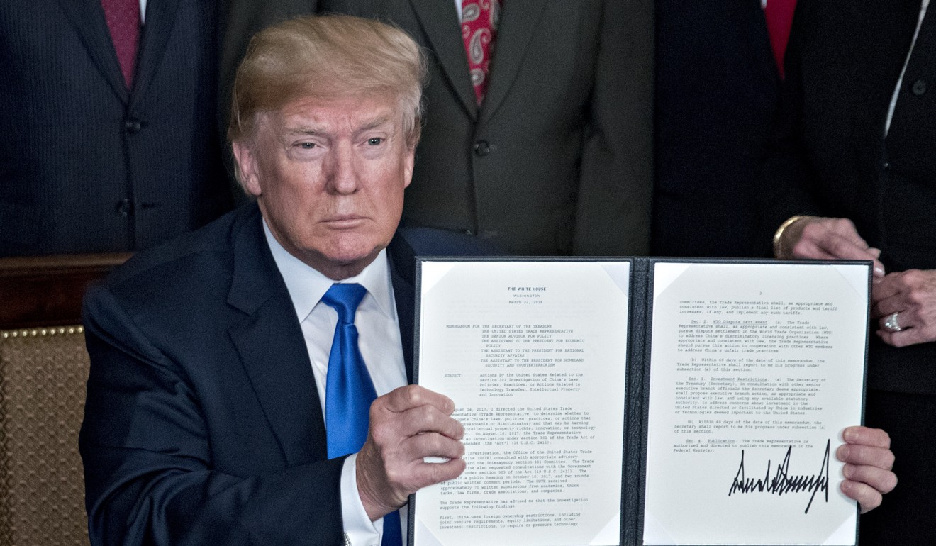 US President Donald Trump holds up a signed presidential memorandum targeting China's economic aggression in the Diplomatic Room of the White House on Thursday. Photo: Bloomberg