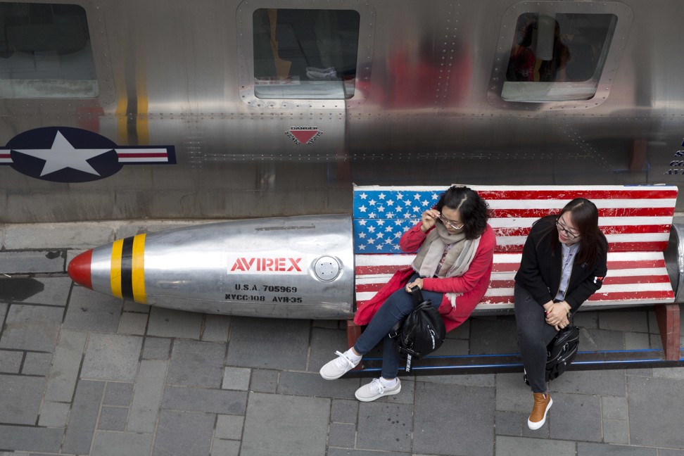 Women sit on a bench with a US flag theme in Beijing. A commentary in People’s Daily on Saturday suggested that a trade war between China and the US would hurt Donald Trump’s prospects of re-election in 2020. Photo: AP