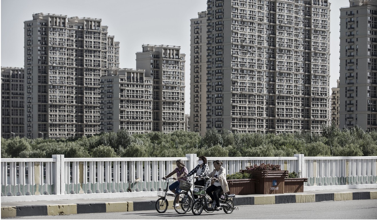 Commuters ride past new residential buildings in Baotou, Inner Mongolia. Photo: Bloomberg