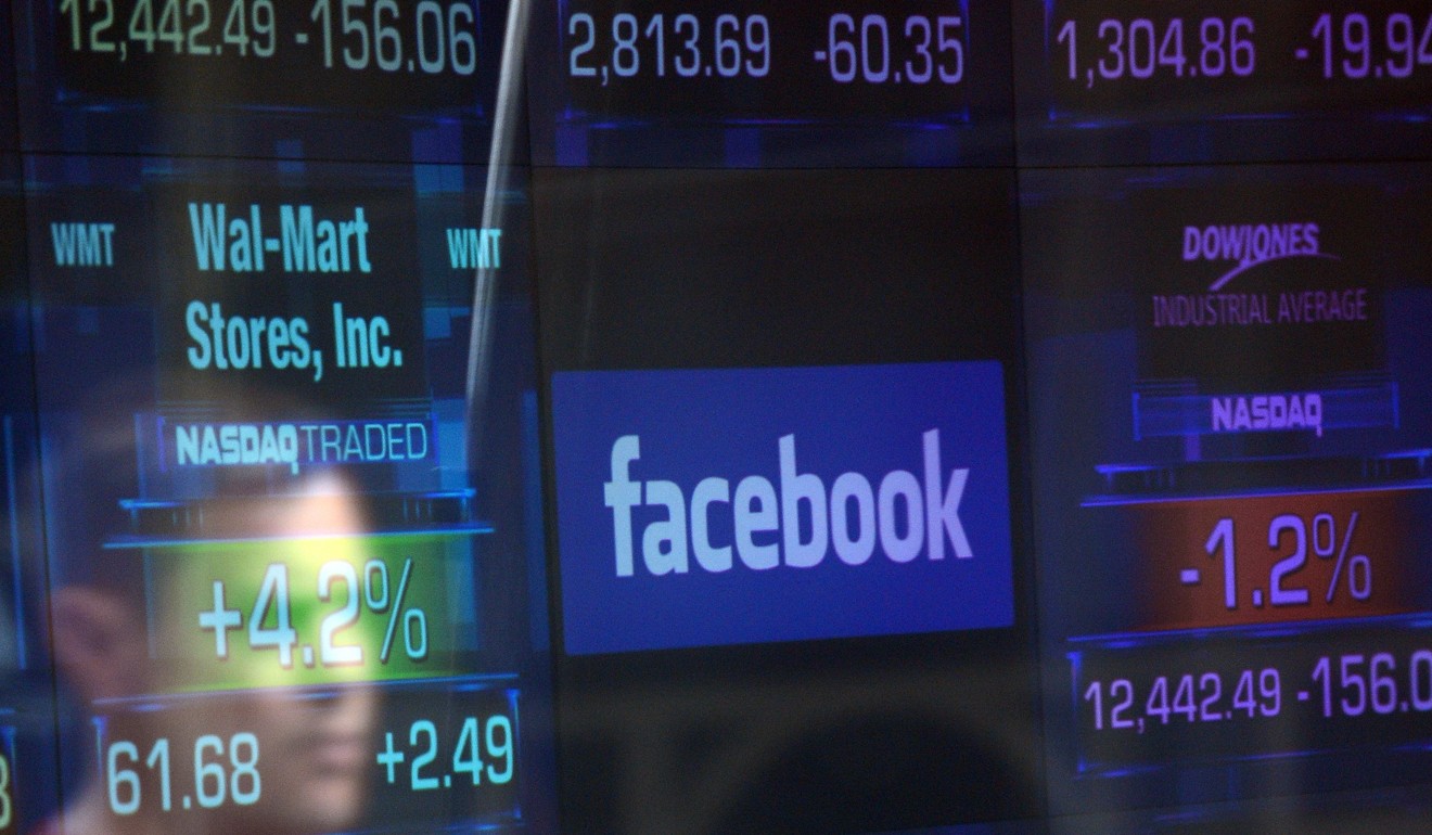 In this file photo taken on May 17, 2012, a Facebook logo is seen through the windows of the NASDAQ stock exchange as people walk by on Times Square in New York. Facebook shares tumbled following reports of a privacy scandal involving Cambridge Analytica. Photo: AFP 