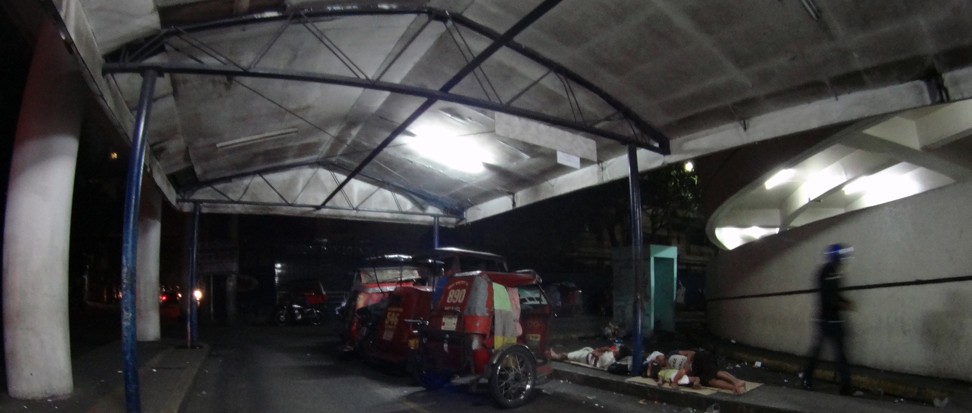 Riders sleep by their bikes at a tricycle pickup spot in Quezon City. Photo: SCMP