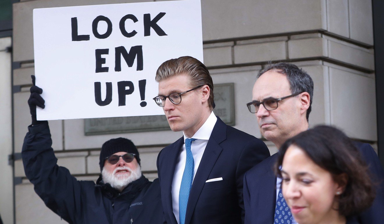 Alex van der Zwaan leaves Federal District Court in Washington, on April 3, 2018. Holding the sign up is Bill Christeson from the Washington area. A federal judge sentenced Alex van der Zwaan to 30 days in prison. Photo: AP 